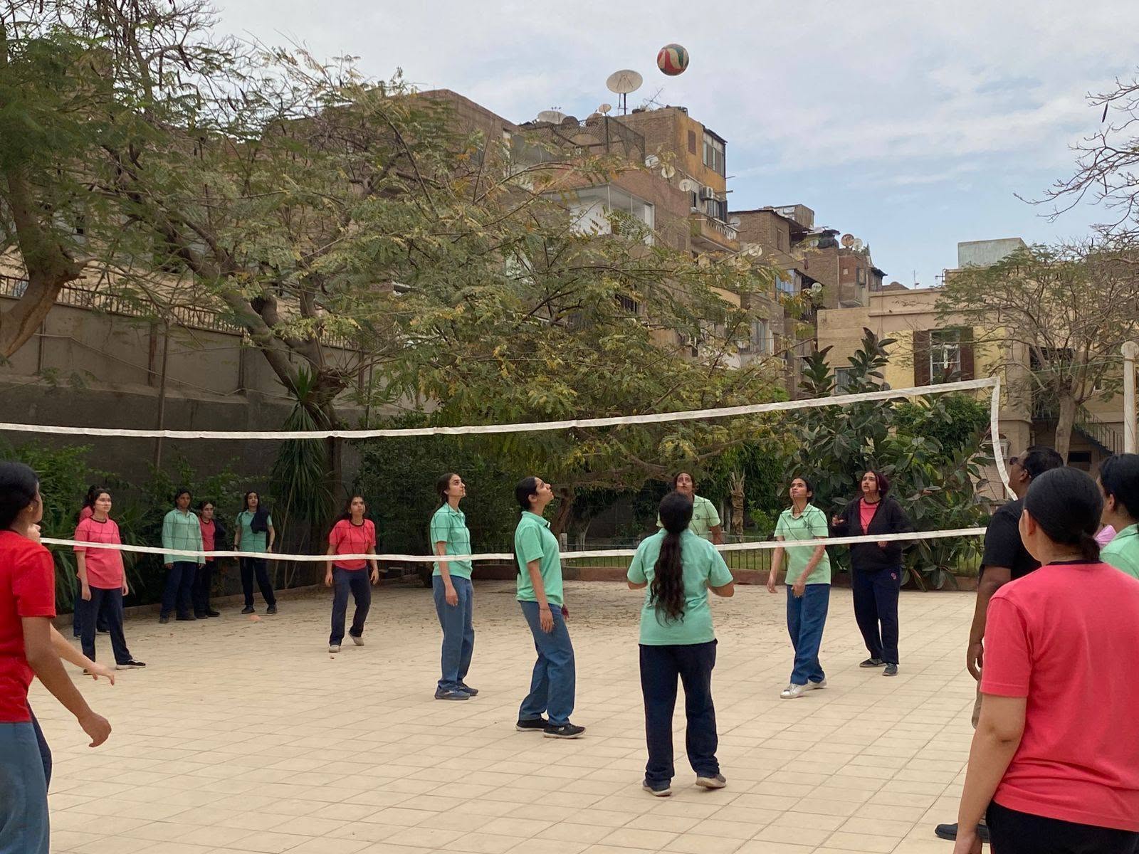 Students playing volleyball in the school courtyard